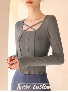 Close-up of grey ribbed knit yoga top featuring cross strap neck and decorative buttons