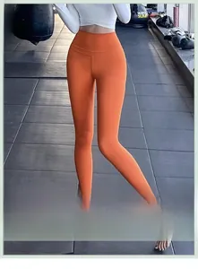 Détail du pantalon de yoga orange à taille haute montrant la texture liftante et le tissu stretch