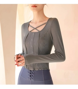 Close-up of charcoal grey ribbed yoga top with cross-strap neck and button detail
