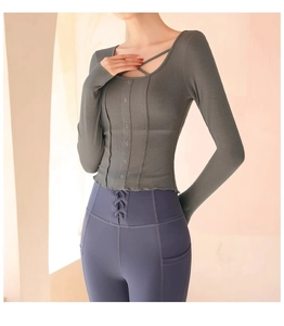 Detail view of grey long sleeve yoga top with ribbed texture and crossover neckline