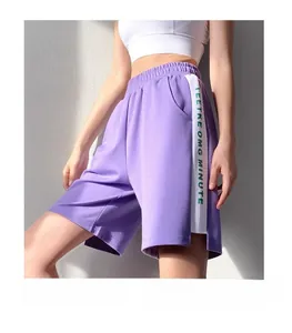 Détail de short de sport violet ample avec taille élastique et rayures contrastées