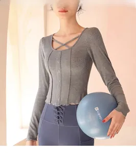 Detail of grey ribbed yoga long sleeve with U-neckline cross straps and decorative buttons