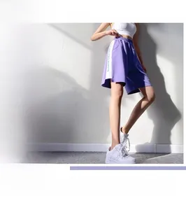 Détail d'un short de sport violet taille haute ample avec rayures et ceinture élastique