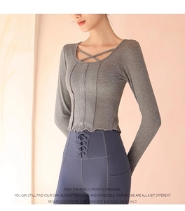 Close-up of gray ribbed knit yoga top with decorative buttons and cross-strap neckline