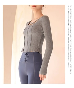 Detail of grey slim-fit yoga top with ribbed texture, criss-cross neck and wavy hem