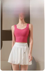 Detail view of pink racerback sports top and white pleated skirt with drawstring waist