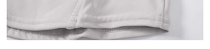 Vue macro des doubles coutures sur l'ourlet d'un sweat à capuche yoga gris clair