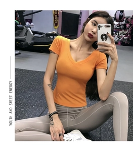 Detalle de la camiseta deportiva naranja brillante con cuello en V y tejido acanalado