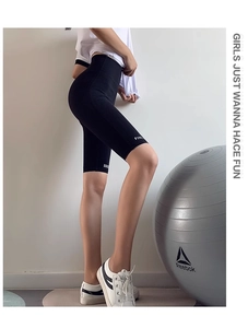 Gros plan sur le short de yoga noir taille haute avec texte blanc et coupe ajustée