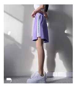 Vue détaillée du short de sport violet avec bandes latérales blanches et imprimé vert