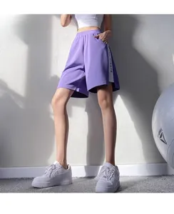 Gros plan d'un short de sport violet avec taille haute élastique et rayures blanches