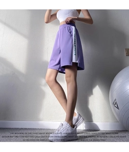Détail d'un short de sport violet avec taille élastique large et bande latérale
