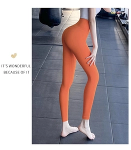 Détail macro du legging de yoga sans couture orange à taille haute avec contrôle du ventre