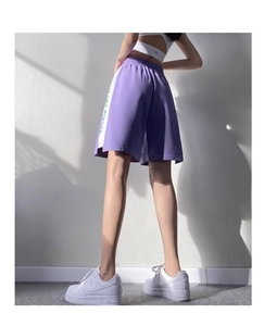 Détail du short de sport violet montrant les bandes blanches et le texte Keep Going
