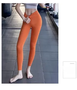 Taille haute en V d'un legging de yoga orange vif présenté dans une salle de sport