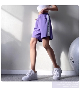 Détail du short de sport violet ample avec rayures latérales et taille haute élastique