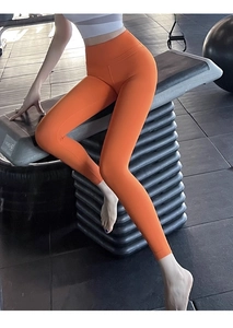 Détail du legging de yoga taille haute orange vif avec coupe de compression élastique