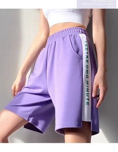 Détail du short de sport violet avec taille élastique et rayures blanches latérales