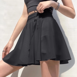 Women's black high-waisted pleated tennis skirt and crop top athletic set with drawstring
