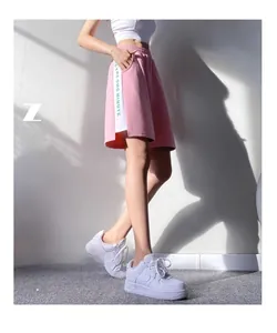 Vue détaillée du short de sport rose avec bandes latérales et texte sur le mannequin