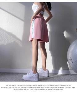 Détail du short de sport rose avec bandes latérales blanches et taille élastique large