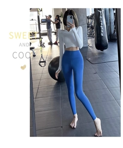 Selfie miroir montrant haut court blanc à col en V et legging de yoga bleu à taille haute