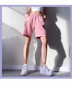 Détail du short de sport rose ample avec taille élastique et imprimé de lettres latéral
