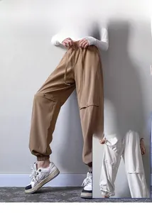 Detail of adjustable snap button design on khaki and white baggy cargo fitness pants