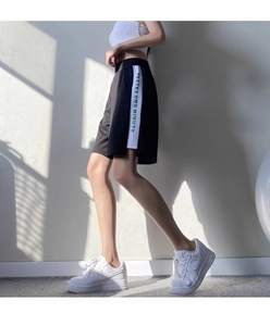 Vue détaillée du short de sport noir avec bandes latérales contrastées et lettrage vert