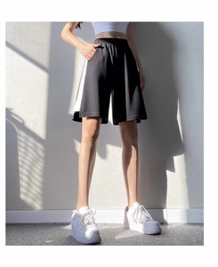 Détail du short de sport ample à taille haute avec bandes latérales contrastées et élastique