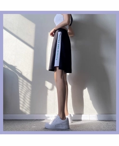 Détail de short de sport ample avec bandes latérales et lettrage TEETKE OMG MINUTE