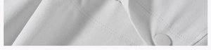 Macro shot of white joggers fabric detail showing resin button and double-line stitching
