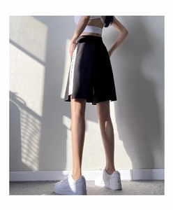 Détail du short de sport noir taille haute avec bande blanche lettrée et taille élastique