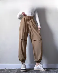 Detail of khaki drawstring joggers with cargo button flap pockets and cuffed ankles