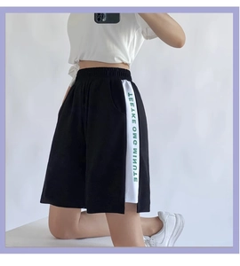 Détail du short de sport noir avec rayures latérales blanches et logo texte vert