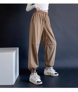 Detail of coffee brown cargo sweatpants with elastic drawstring waist and knee pleats