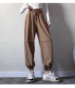 Detail of cargo jogger showing elastic drawstring waistband and metal buckle flap pocket