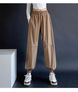 Detail view of high-waist joggers with elastic drawstring and functional cargo pockets