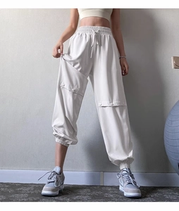 Detail of off-white athletic cargo pants with elastic waist and buttoned side pocket
