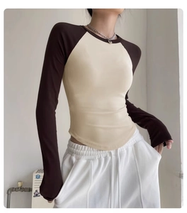 Detail of color-block slim yoga top with raglan sleeves and curved hem for women