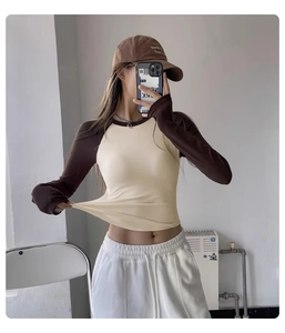 Detail of high-elasticity fabric showing stretch of the beige and brown yoga top