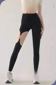 Détail du pantalon de yoga noir à taille haute avec découpe et boucles métalliques
