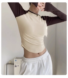Detail of color-block yoga top showing ribbed cotton texture and curved hemline