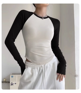 Detail view of slim-fit two-tone yoga top with raglan sleeves and curved hemline