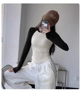 Close-up of slim fit raglan sleeve yoga top with contrast color white and black design