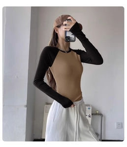 Detail of slim fit color block yoga top featuring khaki body and black raglan sleeves