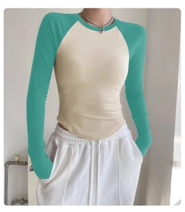 Close-up of the curved hem and contrast stitching on a slim fit mint yoga top