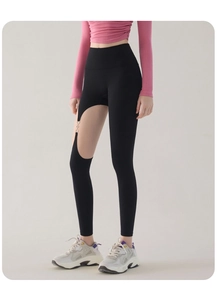 Détail du pantalon de yoga noir taille haute avec découpes et anneaux métalliques argentés