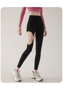 Détail du pantalon de yoga noir taille haute avec découpes et anneaux métalliques argentés