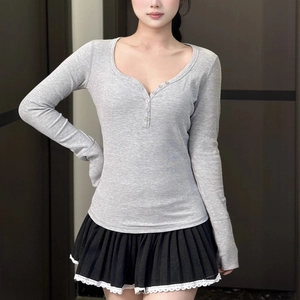 Détail du haut Henley gris à col en V avec boutons et texture en maille côtelée